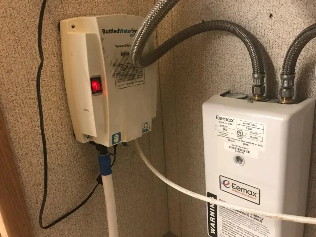 A close-up of the ambient water pump system with visible piping and electrical connections