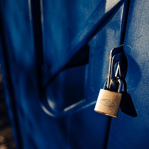 A close-up of a golden padlock securing a blue metal door