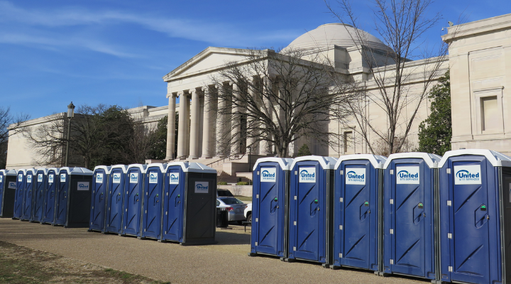 a line of blue and white toilets outside of the entrance of a marble government building