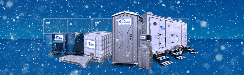 Blue background with white snow falling in front of a group of site service products. A grey porta potty and hand washing sink in front, with a water tank, waste tank and blue dumpster on the left. A white restroom trailer on the right and a chain link fence in the back,