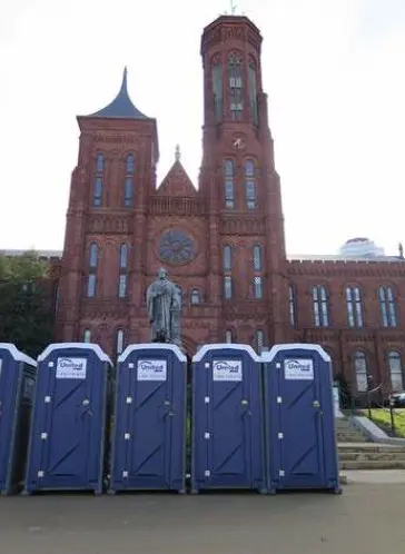 five porta potties setup in front of a municipal building