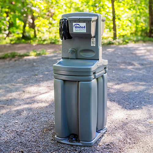 a double sided hand washing station on a trail in the woods